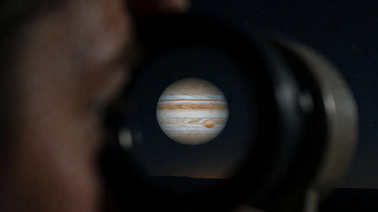 View through a telescope eyepiece showing Jupiter distorted by atmospheric turbulence and mirage.