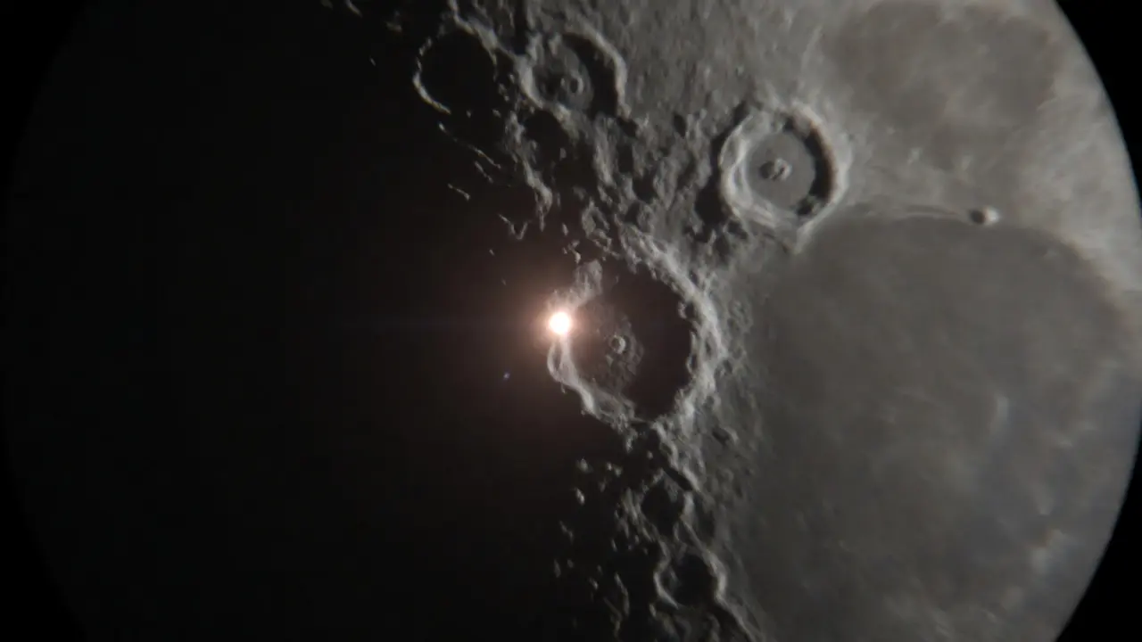 Close-up of a bright impact flash on the lunar surface near a crater